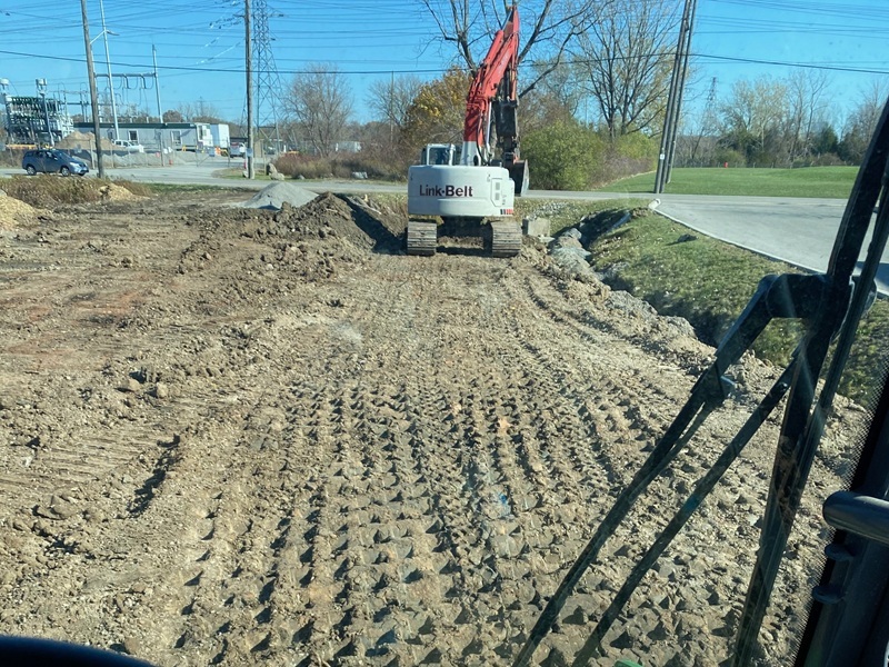Cleared construction site with earthmoving equipment and material stockpiles
